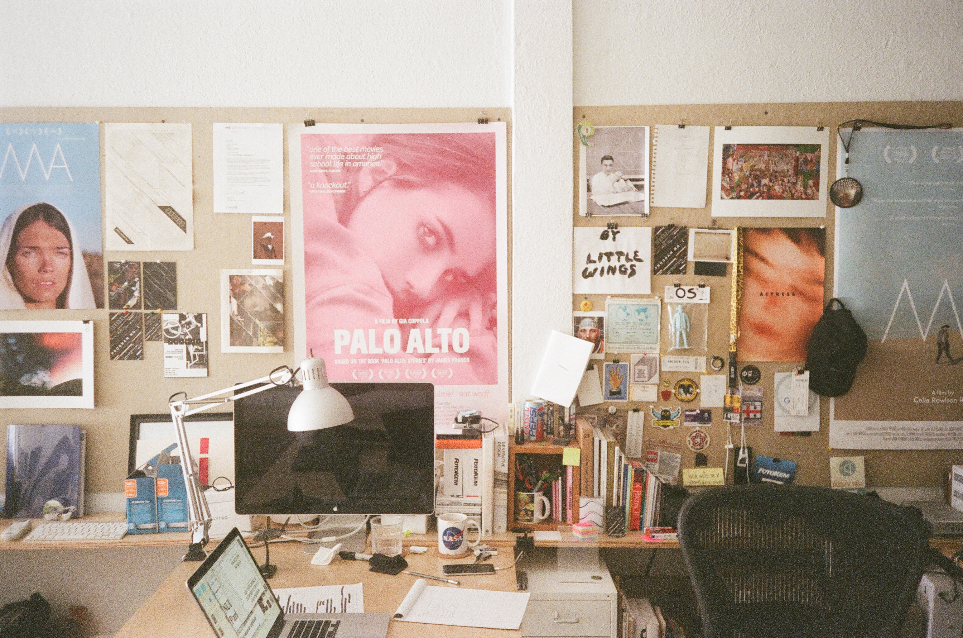 Photograph of a desk and bulletin boards filled with posters and postcards from Memory films.