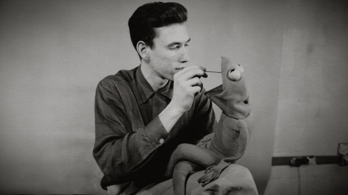 Black and white image of Jim Henson with a Kermit puppet.