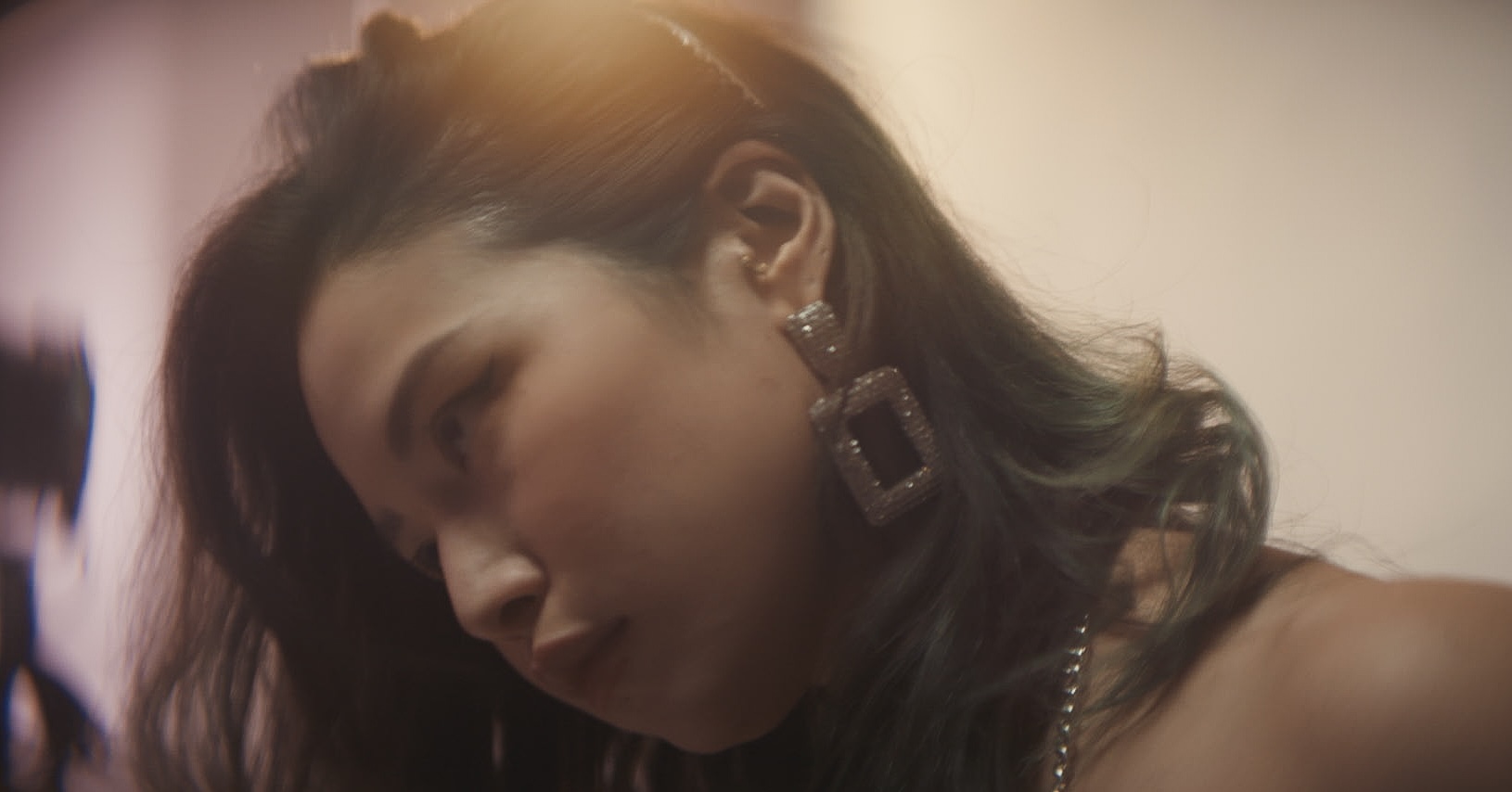 Hazy photograph of a young Vietnamese woman with large earrings.