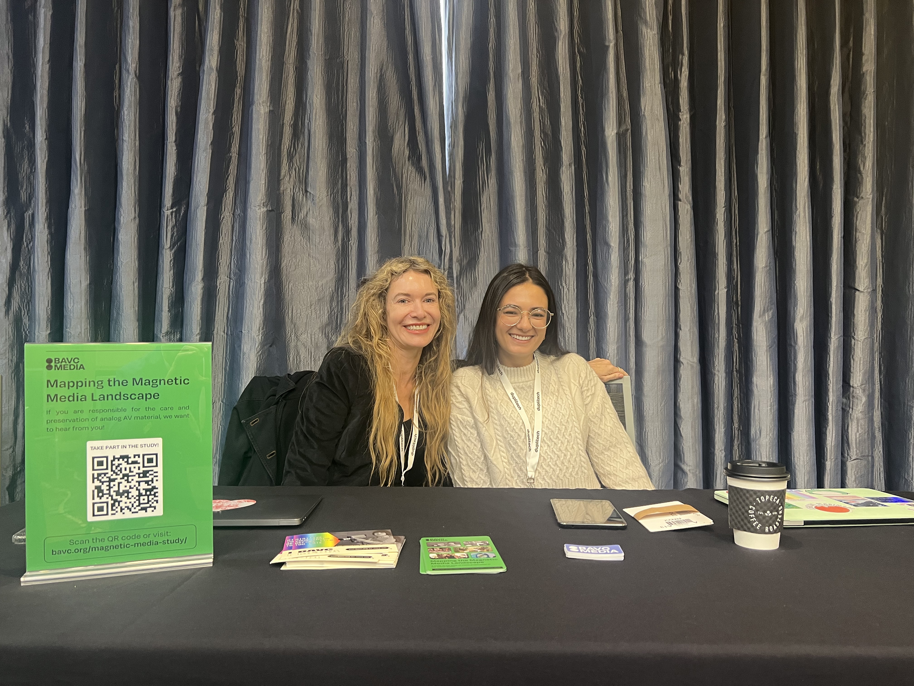 Two white women sit at a booth.