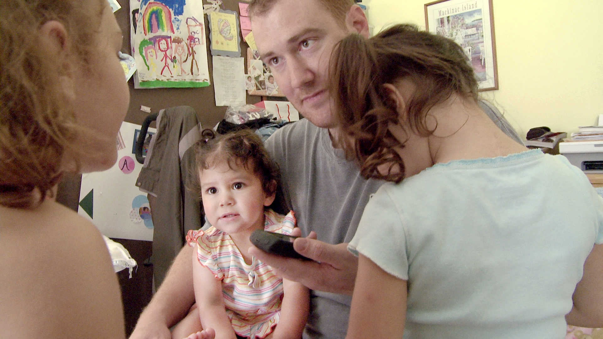 Cindy Shank's then-husband, Adam, with their kids, talking to Cindy on the phone. Courtesy of HBO