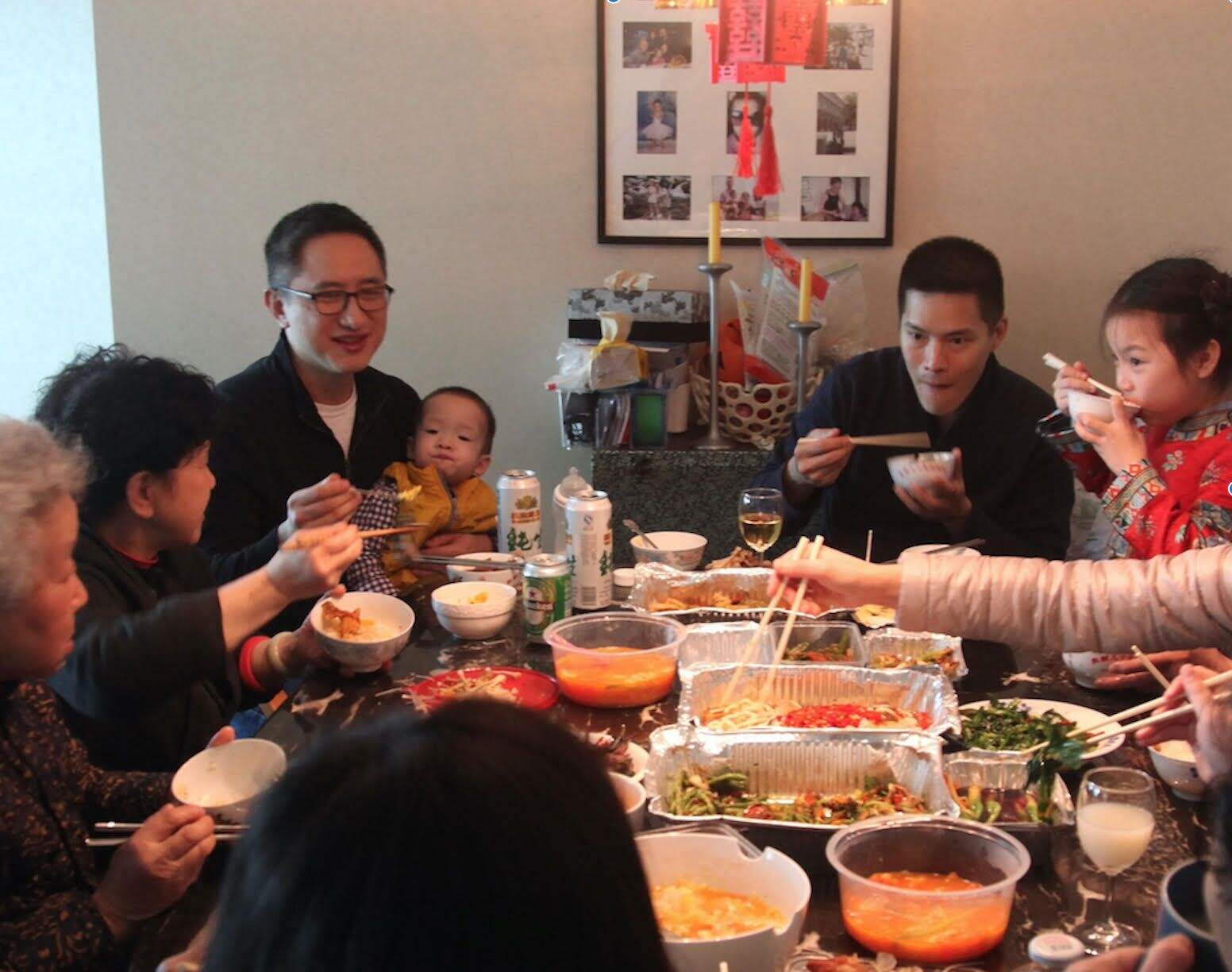 Filmmaker Hao Wu is a Chinese American male. Seen here sitting eating at a table with his child, his family members, and partner. From Hao Wu’s ‘All in My Family.’ Courtesy of Netflix.