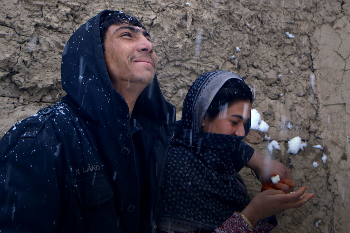 A young Afghan couple pictured in the snow. Image from Elizabeth and Gulistan Mirzaei’s ‘Three Songs for Benazir,’ which is set and filmed in refugee camps in Afghanistan. Courtesy of the filmmakers.