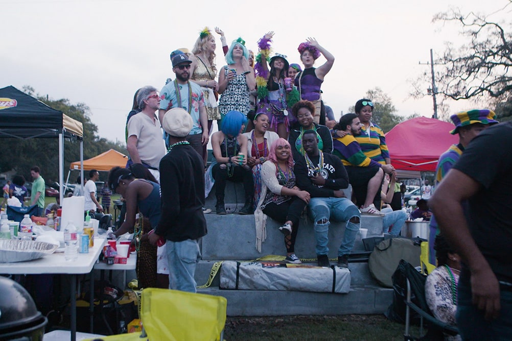 Black and white costumed New Orleanians celebrate Mardi Gras on the pedestal of a now absent confederate monument. From CJ Hunt and Darcy McKinnon’s The Neutral Ground. Photo by Paavo Hanninen. Courtesy of POV.