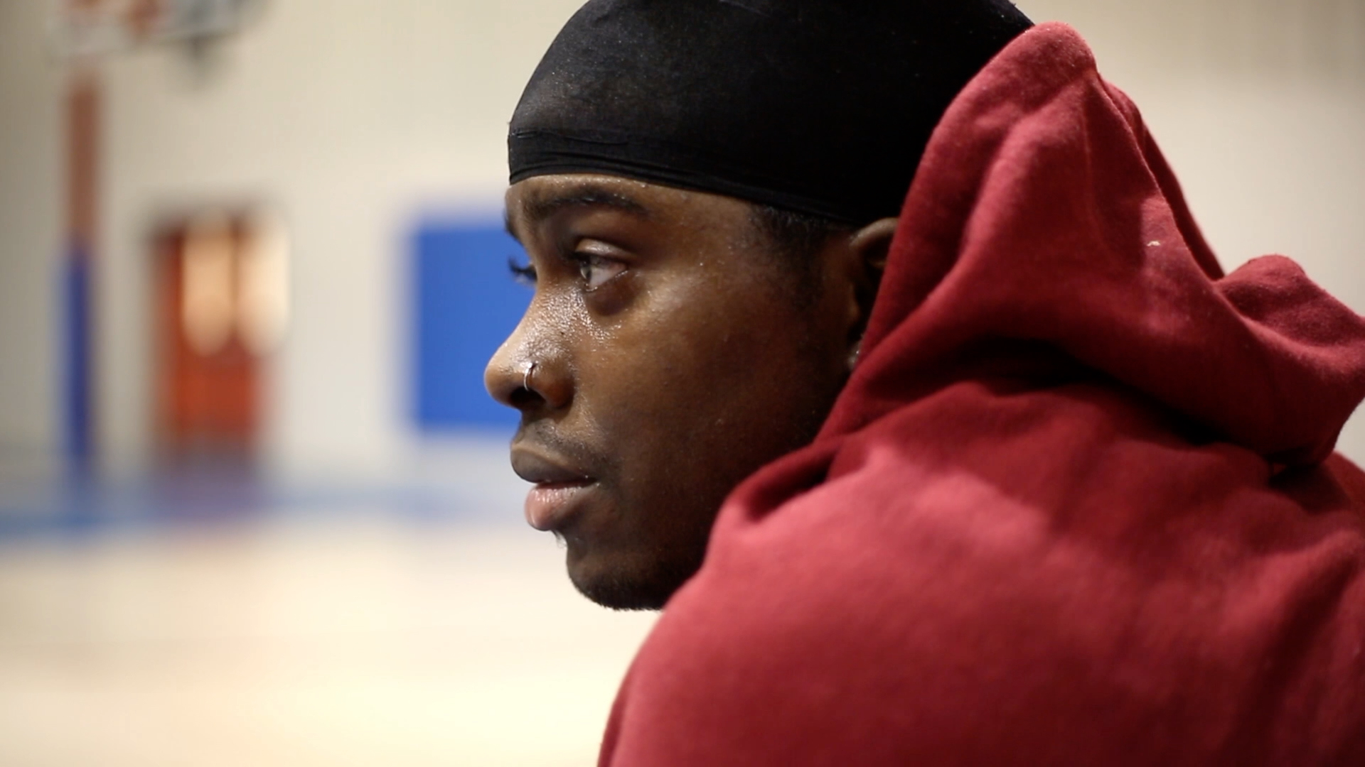 A young Black man looks into the distance.