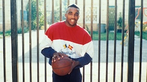 A young man holds a basketball.