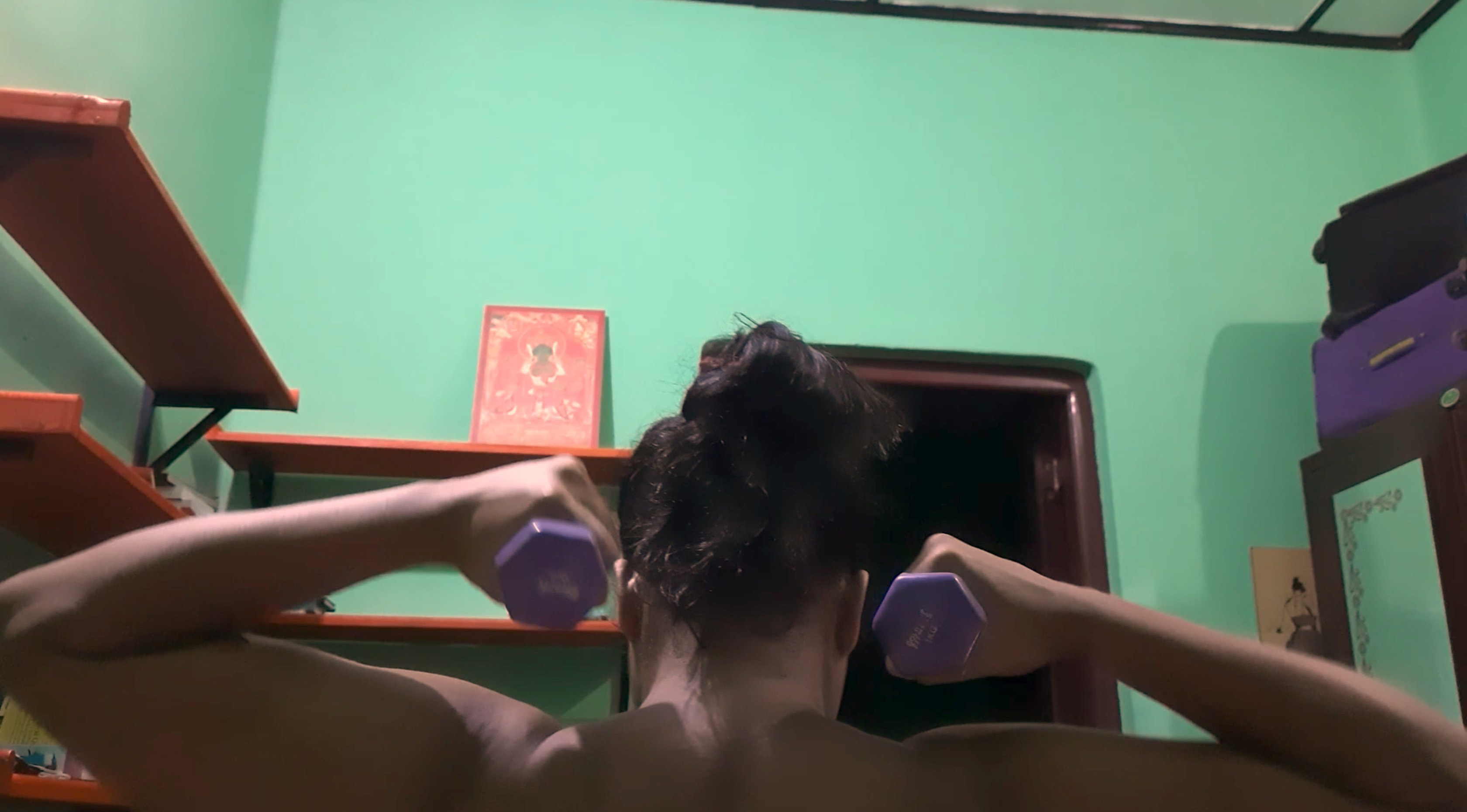 The back of a person holding weights.