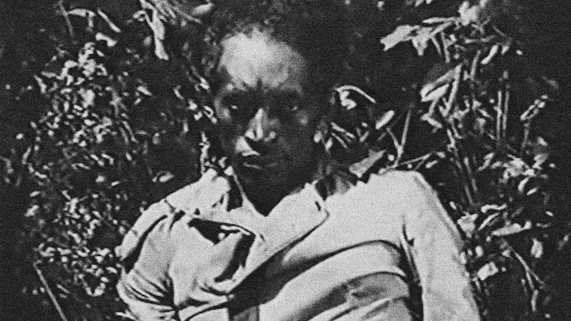 Black and white still from 'The White Death of the Black Wizard,' depicting a Black man staring in the camera.