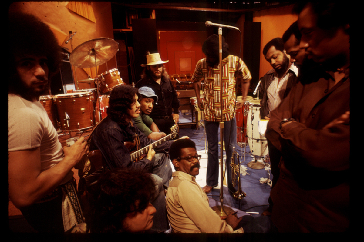 From Melissa Haizlip's 'Mr. SOUL!' Courtesy of Alex Harsley. The subject of the documentary, Ellis Haizlip, sits in the middle of the set of his variety show 'SOUL' surrounded by members of the '70s funk band Mandrill, some members of whom are holding their instruments.