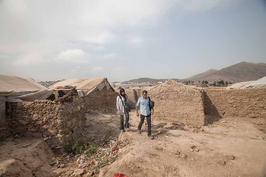 Filmmakers of 'Three Songs for Benazir' walking outside in a displacement camp in Kabul. Courtesy of Gulistan and Elizabeth Mirzaei