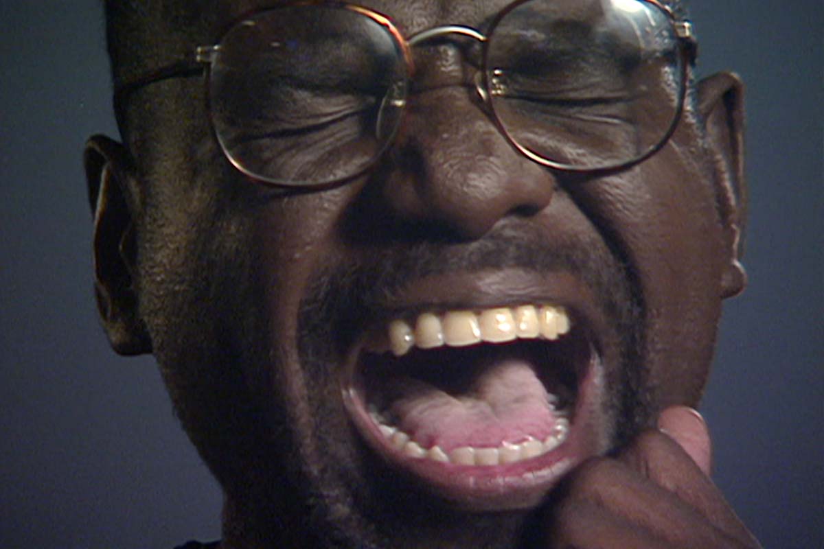 A close up of legendary Black filmmaker Marlon Riggs, where he is seen shouting on screen. Courtesy of The Criterion Collection.