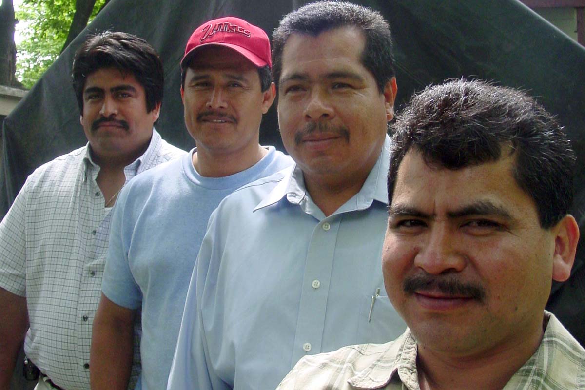 A group of Latino men, all with moustaches and wearing button-down shirts, stand in front of a tent. From Alex Rivera's 'The Sixth Section.' Rivera earned the first Emerging Documentary Filmmaker Award, in 2003. Courtesy of Alex Rivera