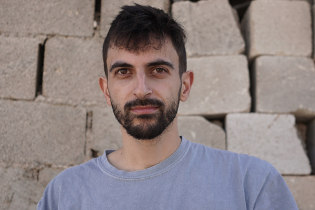Picture of white man against a brick background.