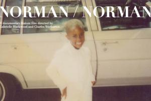 Photograph of a Black child dressed in white standing in front of an older white car, the text Norman/Norman at the top of the image