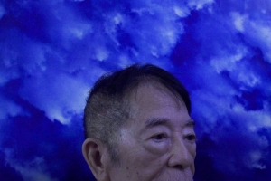 Still from 'Nowhere Near,' depicting the upper half of a Filipino man's head in front of a blue background. Courtesy of the Flaherty.