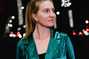 headshot of Polina Herman wearing a green jacket over a black shirt