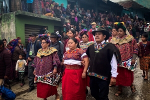 Juanita Alonzo Santizo, arm in arm with her aunt and uncle, Ana and Pedro, parading her in their colorful traditional ceremonial attire through the streets of their hometown San Mateo Ixtatán in Guatemala upon her return after over 7 years wrongfully detained. The whole town surrounds the family and the campaign team.