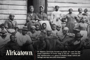 Black and white photograph of a group of enslaved African Americans standing in front of a building