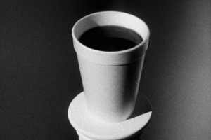 A black and white image of a cup holding a dark liquid.