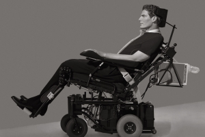 black and white image of a white man in a power chair taken in profile