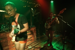 two people with guitars on a lit stage