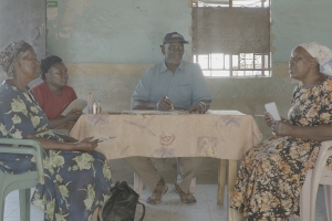 Photo of Rhoda and the Luo council of elders in a pre-mediation meeting