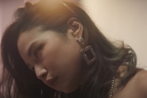 Hazy photograph of a young Vietnamese woman with large earrings.