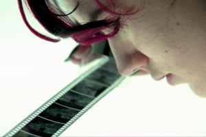 A young woman examines a black and white negative on a light table.