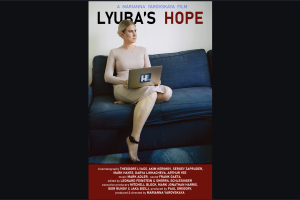 Film poster showing a blonde woman sitting on a couch with an ankle monitor on, holding a laptop.