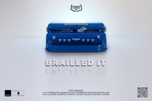 A blue Perkins brailler sits on a white backdrop. The film's title, Brailled It, is beneath the brailler in standard print and braille.