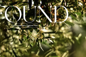 A close-up of a leafy branch of an olive tree with the words "FOUND: A Documentary Feature Film."