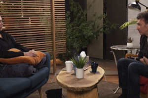 2 people sitting across from each other coffee table between them