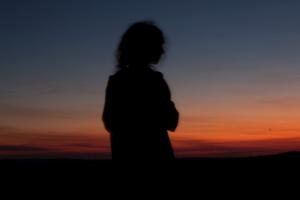Stock image of woman looking onto the sunset.