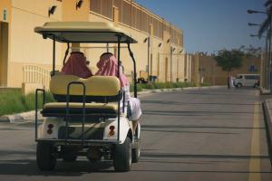 Two Saudi Arabian men wearing keffiyeh and white thobes sitting in a golf cart on the premises of the Mohammed bin Nayef Counseling and Care Center in Riyadh. From Meg Smaker’s ‘Jihad Rehab.’ Courtesy of Sidestilt Films.