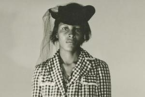 Recy Taylor wears a checkered blouse and a black hat with a veil