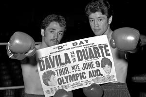 Black and white photo of two boxers holding a newspaper