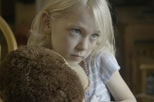Transgender child and main subject of Mama Bears holding a stuffed toy.