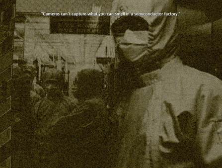 A person in safety gear and a mask looks at the camera, standing next to the door to a room where more people in the same gear are pictured inside.