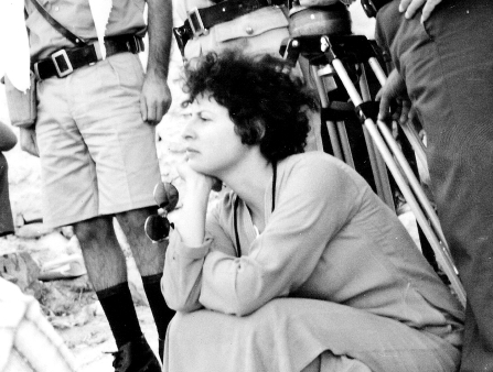Black and white photo of a young woman in front of a camera and her crew.