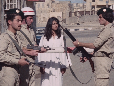 A woman in white talks to three male soldiers.