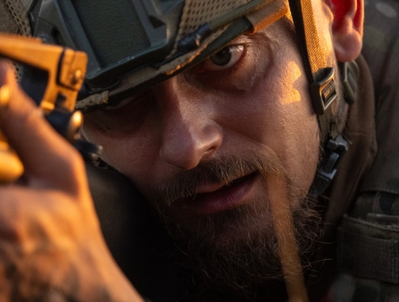 Close-up of soldier's face holding his gun