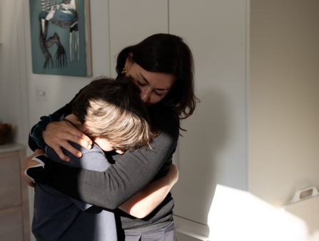 A woman hugs her child.