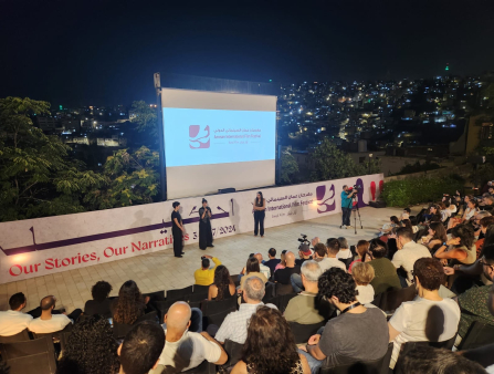 Post-screening Q&A in an outdoor theater overlooking a city nightscape.