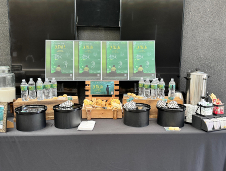 Drinks and refreshments on a table branded with green and yellow posters for the film La Falla