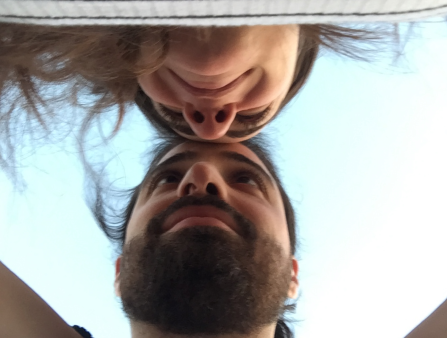 Photo taken from below of a bearded man and a woman embracing and touching foreheads
