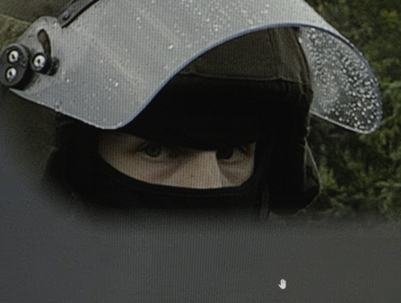 Zoomed in shot of a man in a riot helmet, with only his eyes exposed.
