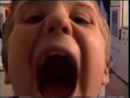 Close up image of a young boy with a gaping open mouth