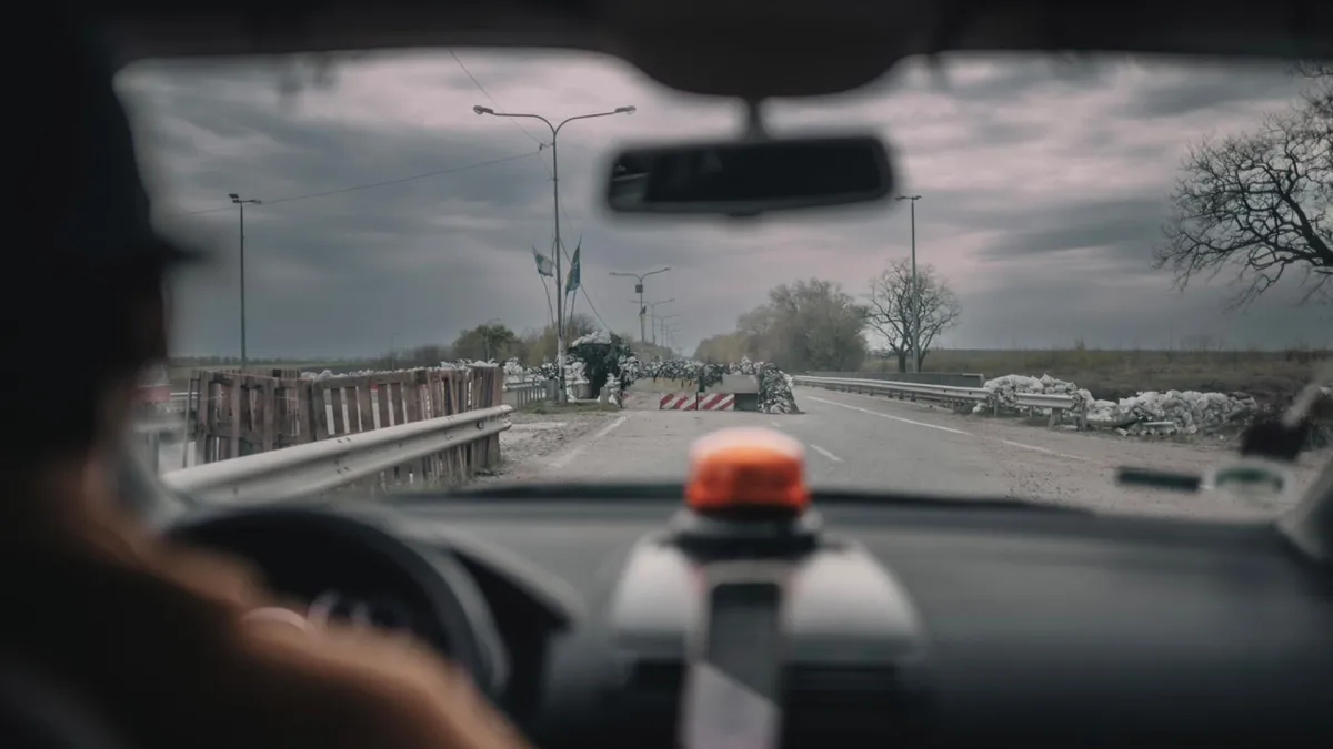 Still from 'In the Rearview,' depicting a view of a road blockade from the inside of a van.