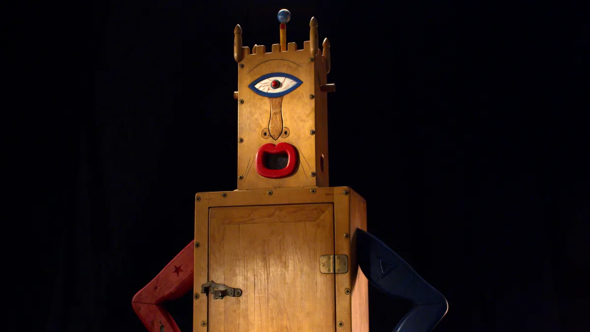 Still image from 'Westermann: Memorial to the Idea of Man If He Was an Idea,' depicting one of Westermann's wood sculptures against a black background.