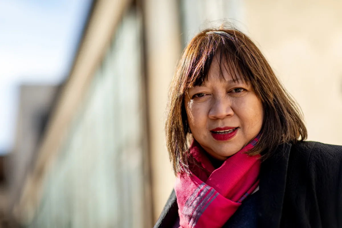 headshot of Ramona Diaz wearing a red plaid scarf and black jacket